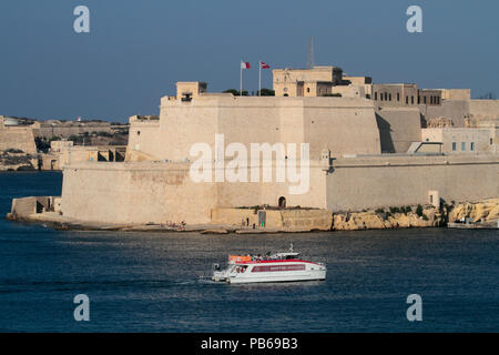 Die Malta Grand Harbour Fähre vorbei an historischen Fort St. Angelo während der Überfahrt von Valetta nach Nouméa. Reisen und Tourismus in Malta. Stockfoto