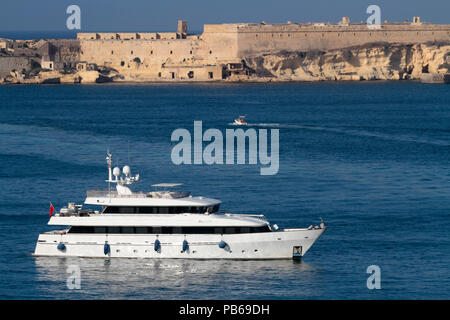 Die 35 m Heesen Luxusyacht Alcor in Maltas Grand Harbour, mit Fort Ricasoli in der Ferne die Bewachung der Hafeneinfahrt Stockfoto