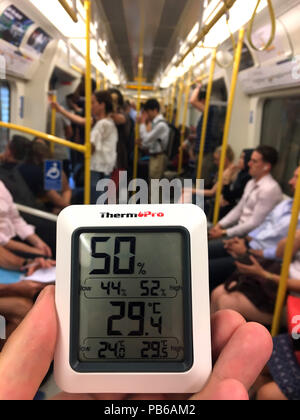 Ein Thermometer zeigt 29,4 C auf der Circle Line während der Rush Hour. Rush-hour Pendler in der Londoner U-Bahn sweltered bei Temperaturen über dem gesetzlichen Grenzwert für den Transport von Vieh am Donnerstag, den heißesten Tag des Jahres bis jetzt. Stockfoto