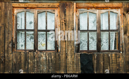 Zwei alte Holzfenster in einem alten Holzhaus Stockfoto