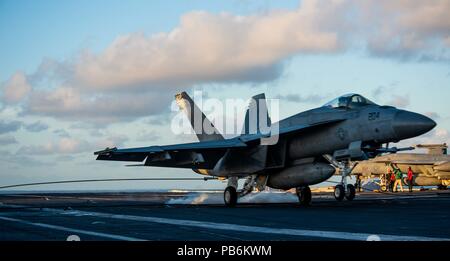 180720-N-OY 799-0306 philippinischen Meer (Juli 20, 2018) Eine F/A-18E Super Hornet zu Strike Fighter Squadron (VFA) 27 landet auf dem Flugdeck der Marine vorwärts zugeordnet - bereitgestellt Flugzeugträger USS Ronald Reagan (CVN 76). Ronald Reagan, das Flaggschiff der Carrier Strike Group 5, bietet eine Bekämpfung bereit, Kraft, schützt und verteidigt die kollektive maritime Interessen seiner Verbündeten und Partnern in der indopazifischen Region. (U.S. Marine Foto von Mass Communication Specialist 2. Klasse Kenneth Abbate / freigegeben) Stockfoto