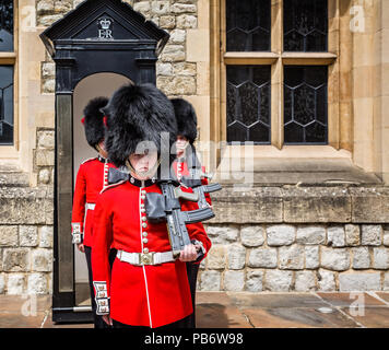 Gardisten in Bärenfellmütze Hüte im Tower of London, London, Großbritannien am 8. Juli 2017 getroffen Stockfoto
