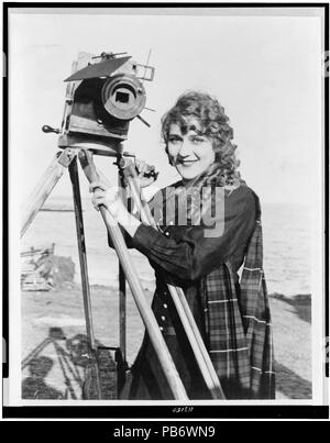 . Mary Pickford, Brustbild, stehend, mit leicht nach links, mit Kamera, am Strand. ca. 1916 1003 Mary Pickford mit Kamera Stockfoto