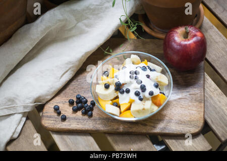 Haferflocken oder Müsli mit Joghurt und Obst und Beeren. Pfirsich, Mango, Banane, Heidelbeere, Himbeere apple Stockfoto