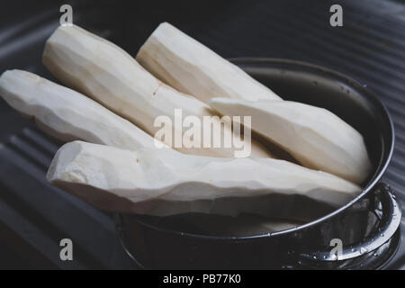 Maniok (Manihot esculenta) (Spanisch: mandioca, Guarani: mandi'o), wurzeln in der Schüssel geschält, auf Waschmaschine Spülbecken, Draußen, Asuncion, Paraguay. Vintage Farben Stockfoto