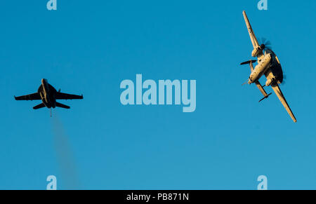 180720-N-OY 799-0296 philippinischen Meer (Juli 20, 2018) Eine F/A-18 Super Hornet und eine E-2D Hawkeye fliegen in Formation über das Flight Deck der Marine vorwärts - bereitgestellt Flugzeugträger USS Ronald Reagan (CVN 76). Ronald Reagan, das Flaggschiff der Carrier Strike Group 5, bietet eine Bekämpfung bereit, Kraft, schützt und verteidigt die kollektive maritime Interessen seiner Verbündeten und Partnern in der indopazifischen Region. (U.S. Marine Foto von Mass Communication Specialist 2. Klasse Kenneth Abbate / freigegeben) Stockfoto