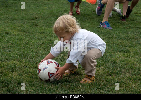 Ein Junge herauf ein Fußball während der schwedischen Mittsommer Festival in Battery Park City. Stockfoto