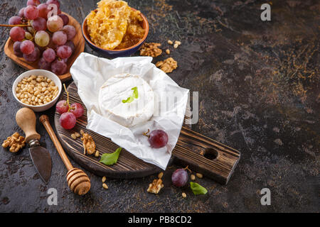 Camembert Käse mit Trauben, Honig in den Waben mit Zedern- und Walnüsse und Mandeln. Für text Stockfoto