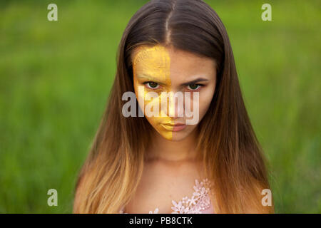 Nahaufnahme Porträt einer schönen jungen Mädchen in weißen Akazie im Frühjahr die Hälfte Gesicht goldene Make-up Stockfoto