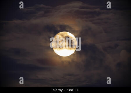 Hellen Vollmond gegen dunkle Wolken Stockfoto