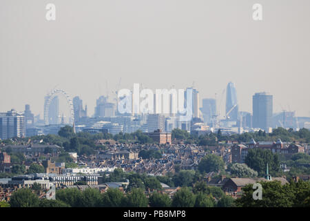 London. VEREINIGTES KÖNIGREICH. Juli 2018. Die Skyline von London und Wahrzeichen von Wimbledon aus durch einen Hitzeeintrübung mit Vorstadthäusern im Vordergrund, wenn die Temperaturen an einem Feiertagswochenende ansteigen. Kredit: amer ghazzal/Alamy Live Nachrichten Stockfoto