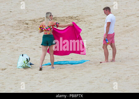 Bournemouth, Dorset, Großbritannien. 27. Juli 2018. UK Wetter: Sunseekers Kopf am Meer in der Sonne am Bournemouth Strände an einem warmen feuchten Tag mit etwas Bewölkung zu tränken. Credit: Carolyn Jenkins/Alamy leben Nachrichten Stockfoto