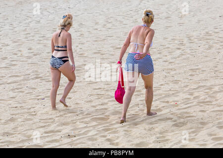 Bournemouth, Dorset, Großbritannien. 27. Juli 2018. UK Wetter: Sunseekers Kopf am Meer in der Sonne am Bournemouth Strände an einem warmen feuchten Tag mit etwas Bewölkung zu tränken. Zwei Frauen Spaziergang entlang der Sand. Credit: Carolyn Jenkins/Alamy leben Nachrichten Stockfoto