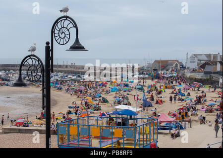 Lyme Regis, Dorset, Großbritannien. Juli 2018. UK Wetter: Heiß und klebrig in Lyme Regis. Britische Urlauber fahren in den Badeort Lyme Regis, um den schönen Strand zu genießen, während das Vereinigte Königreich in heißen und schwül Temperaturen schwelgt. Das Quecksilber wird heute in Teilen Großbritanniens seinen Höhepunkt erreichen, da der „Ofenfreitag“ heiße und donnernden Bedingungen mit sich bringt. Quelle: DWR/Alamy Live News Stockfoto