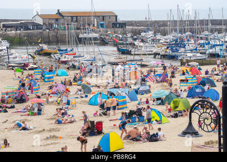 Lyme Regis, Dorset, Großbritannien. Juli 2018. UK Wetter: Heiß und klebrig in Lyme Regis. Britische Urlauber fahren in den Badeort Lyme Regis, um den schönen Strand zu genießen, während das Vereinigte Königreich in heißen und schwül Temperaturen schwelgt. Das Quecksilber wird heute in Teilen Großbritanniens seinen Höhepunkt erreichen, da der „Ofenfreitag“ heiße und donnernden Bedingungen mit sich bringt. Quelle: DWR/Alamy Live News Stockfoto