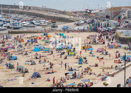 Lyme Regis, Dorset, Großbritannien. Juli 2018. UK Wetter: Heiß und klebrig in Lyme Regis. Britische Urlauber fahren in den Badeort Lyme Regis, um den schönen Strand zu genießen, während das Vereinigte Königreich in heißen und schwül Temperaturen schwelgt. Das Quecksilber wird heute in Teilen Großbritanniens seinen Höhepunkt erreichen, da der „Ofenfreitag“ heiße und donnernden Bedingungen mit sich bringt. Quelle: DWR/Alamy Live News Stockfoto