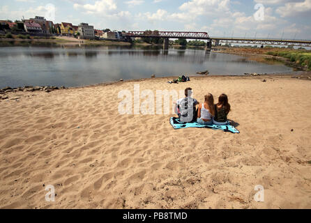 Schoenebeck, Deutschland. 27. Juli, 2018. Eine Gruppe junger Leute sitzen am Ufer der Elbe gegenüber der Stadt Schönebeck. Der niedrige Wasserstand der Elbe macht die Sandbänke sichtbar. Das Niveau hier ist normal bei 240 Zentimeter, derzeit ist es nur 68 Zentimeter. Credit: Peter Förster/dpa-Zentralbild/dpa/Alamy leben Nachrichten Stockfoto