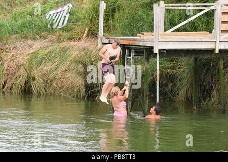 Junge Menschen tragen nur Shorts in einen Fluss im Sommer 2018 Hitzewelle in West Sussex, England, Großbritannien springen. Stockfoto