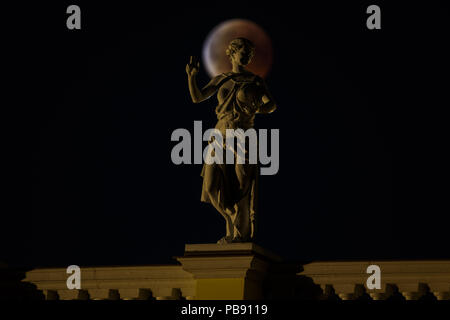 Berlin, Deutschland. 27. Juli 2018. Ein Blut Mond hinter dem Schloss Charlottenburg (deutsch: Schloss Charlottenburg) im Berliner Bezirk Charlottenburg-Wilmersdorf während die längste Mondfinsternis des Jahrhunderts. Der Mond durch das Zentrum von den Schatten der Erde und erscheint wegen der Rayleigh Streuung und die Brechung des Lichtes durch Masse Atmosphäre in seine Umbra rötlich. Kredite: Jan Scheunert/ZUMA Draht/Alamy leben Nachrichten Stockfoto