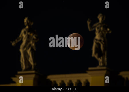 Berlin, Deutschland. 27. Juli 2018. Ein Blut Mond hinter dem Schloss Charlottenburg (deutsch: Schloss Charlottenburg) im Berliner Bezirk Charlottenburg-Wilmersdorf während die längste Mondfinsternis des Jahrhunderts. Der Mond durch das Zentrum von den Schatten der Erde und erscheint wegen der Rayleigh Streuung und die Brechung des Lichtes durch Masse Atmosphäre in seine Umbra rötlich. Kredite: Jan Scheunert/ZUMA Draht/Alamy leben Nachrichten Stockfoto