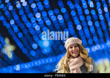 Junge hübsche Frau, die gerne Wandern in der Nacht mit Weihnachtsschmuck. Stockfoto