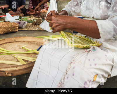 Alte Frau, bambuskörben, canang sari, in einem örtlichen Tempel in Ubud für Nyepi Festival Stockfoto