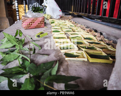 Reihen von Palm Körbe für canang Sari verwendet verlassen und mit Blütenblättern und Reis gefüllt, Bali. Stockfoto