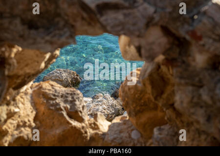 Auf der Suche durch eine kleine Höhle heraus auf das Ägäische Meer, Insel Skiathos, Griechenland Stockfoto