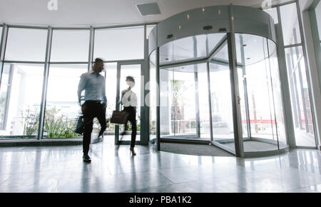 Bewegung verwischt Schuß von zwei Unternehmen, die Menschen sprechen über moderne Büro Flur. Leute, die im Büro Eingang. Stockfoto