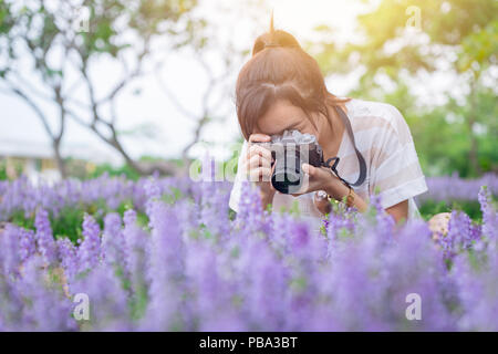 Mädchen teen genießen Urlaub mit Foto schöne Blumen im Park Stockfoto