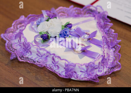 Goldene Hochzeit Ringe auf kleinen weißen Leder Sitzkissen. Stockfoto