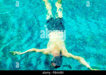 Jungen kaukasischen Mann Schwimmen unter Wasser in einem Pool Stockfoto