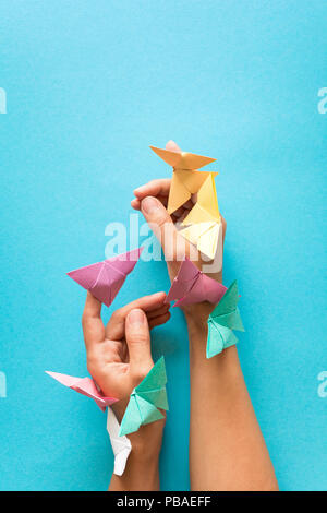 Psychische Gesundheit Konzept. Bunte Papier Schmetterlinge fliegen und sitzen auf womans Hände. Harmonie Emotion. Origami. Papier schneiden Stil. Stockfoto