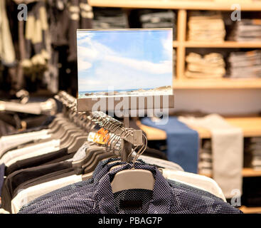 Herren Hemden in verschiedenen Farben auf Kleiderbügeln in einem Ladengeschäft. Showcase, Verkauf, shopping. Mode und Handel Konzept. Stockfoto