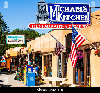 TAOS, NM, USA-8 Juli 18: Eine bunte Bürgersteig Szene in der Altstadt von Taos, mit Zeichen und Pueblo Architektur. Stockfoto