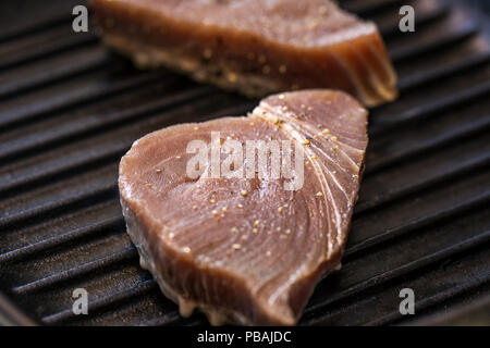 Nahaufnahme von gegrillten Thunfisch Steaks kochen in einer Bratpfanne Pfanne mit Gewürz Stockfoto
