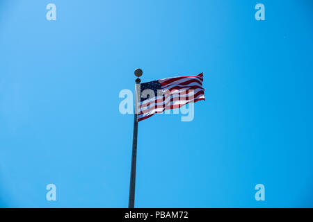 Amerikanische Flagge im Wind flattern auf einem hellen Hintergrund blau Himmel Stockfoto
