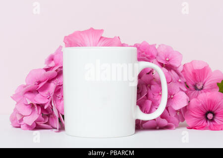 Leere weiße Kaffeetasse mock up mit rosa Blumen Stockfoto