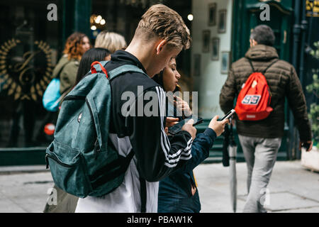 Portugal, Porto, 05. Mai 2018: Junge Menschen auf der Straße und die Nutzung von Mobiltelefonen. Das Leben in der Stadt. Stockfoto