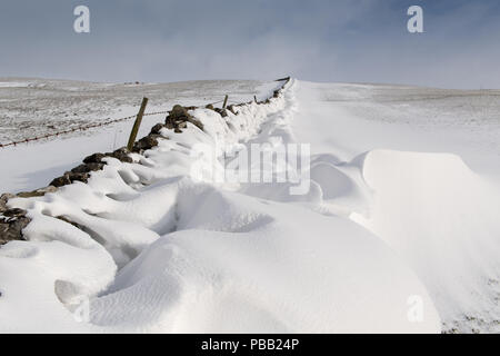 Schneeverwehungen auf der Rückseite der Dystone Wände gebildet, nachdem ein Schneesturm in den Yorkshire Dales, UK. Stockfoto