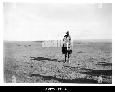 . Englisch: Navajo Indianer Reiter, ca. 1900 Foto von einer Navajo Indianer Reiter, ca. 1900. Seine Hände rest über das Horn des Sattel, wie er gerade Ansätze auf. Er trägt eine Hose und eine lockere Shirt. Sein langes, dunkles Haar ist wieder hinter seinem Kopf gezogen. Er und sein Pferd werfen einen langen Schatten auf der linken Seite auf den kurzen wildgrass bedeckt flache Landschaft. Rufnummer: CHS-3232 Fotograf: Pierce, C.C. (Charles C.), 1861-1946 Dateiname: CHS-3232 Abdeckung Datum: ca. 1900 Teil der Sammlung: California Historical Society Collection, 1860-1960 Typ: Bilder Teil der Teilsammlung: Titel Versicherung ein Stockfoto