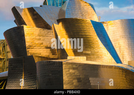 Guggenheim Museum Bilbao, Detail der Stahlverkleidung auf der Oberfläche des Guggenheim Museums, der von einem hellen Sonnenuntergang, Bilbao, Spanien. Stockfoto