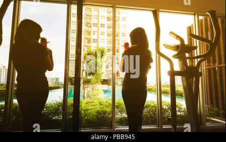 Frau vor der Fenster nach Übung wth Air Walk Maschine in der Morgendämmerung Stockfoto