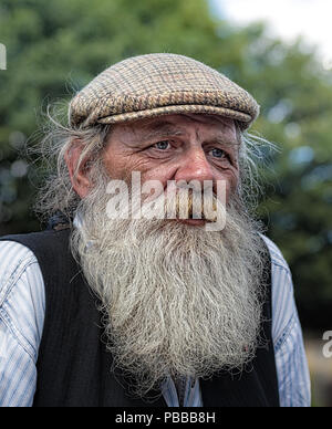 - Nahaufnahme, Frontansicht Portrait von traditionellen Bootsmann mit langen Bart & Flat cap, isoliert arbeiten auf Hausbooten, Black Country Museum UK, 1940 die Veranstaltung. Stockfoto