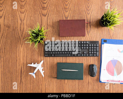 Reisender Geschäftsmann desktop Konzept Bild, Bücher, Stift, Zwischenablage, Topf von Gras Stockfoto