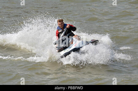 Beach Patrol auf einem Jetski, als die Polizei ihre Suche in der Nähe von Clacton Pier, Clacton-on-Sea, Essex, nachdem ein Teenager wurde berichtet im Wasser am Donnerstag fehlt. Stockfoto