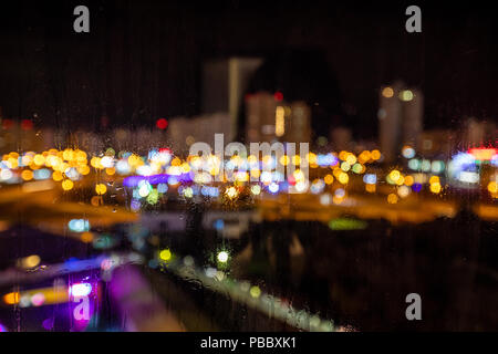 Fällt der Regen in der Nacht am Fenster auf der Rückseite plan wusch die Lichter der Stadt Stockfoto