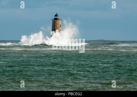 Riesige Wellen aus einem einzigartigen Flut surround Stein Leuchtturm Turm von Whaleback Licht die Sonne bricht durch die Wolken im Süden von Maine. Stockfoto