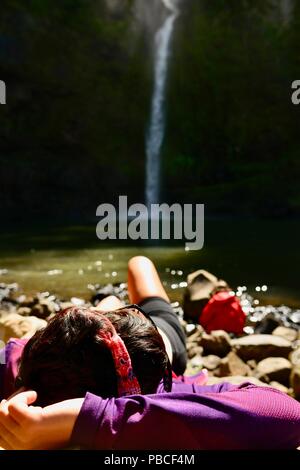 Eine Frau ausruhen und geniessen Sie die wertvollen Momente in der Natur, oben Nandroya fällt, fällt Nandroya fällt, Atherton Tablelands, QLD, Australien Stockfoto