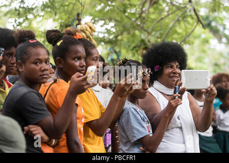 Die lokale Bevölkerung auf Mobiltelefone und Tabletten in Papua Neuguinea Stockfoto